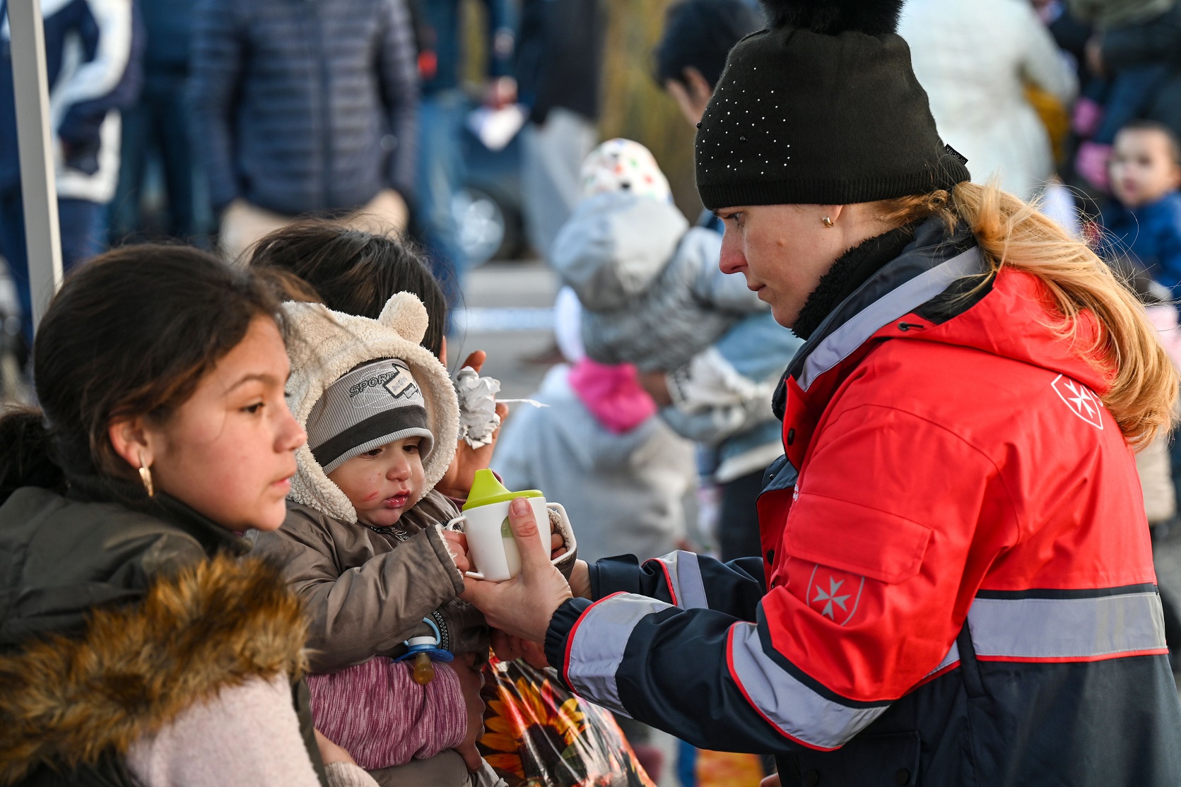 Eine Helferin der ungarischen Malteser verteilt Lebensmittel an Kleindkind_(c) Arpad Csaba Majoros Malteser Ungarn